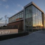 Photo fo WSHU broadcast center with sunrise reflected on the building's windows.