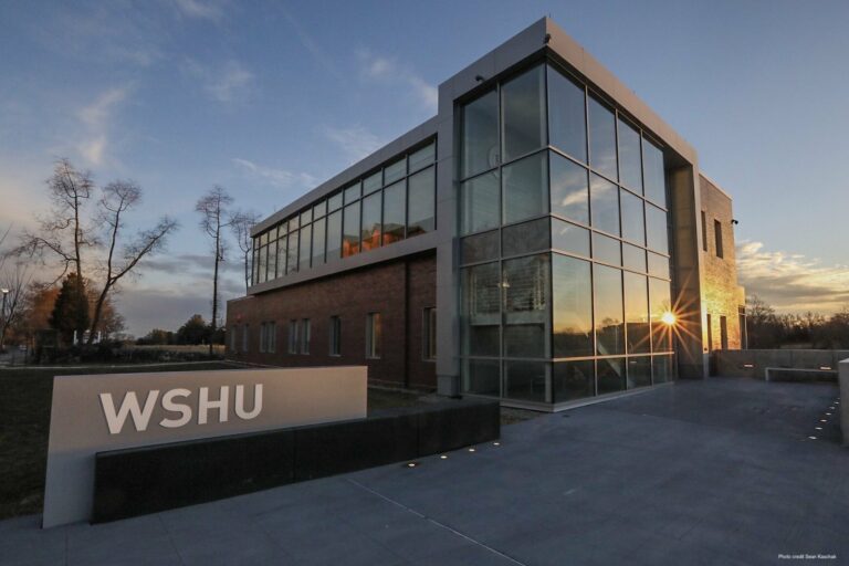 Photo fo WSHU broadcast center with sunrise reflected on the building's windows.